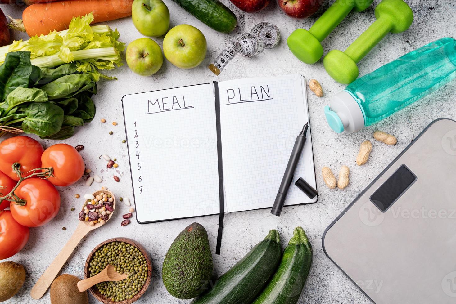 Bloc de notas con plan de comidas de palabras con alimentos saludables y equipamiento deportivo. foto