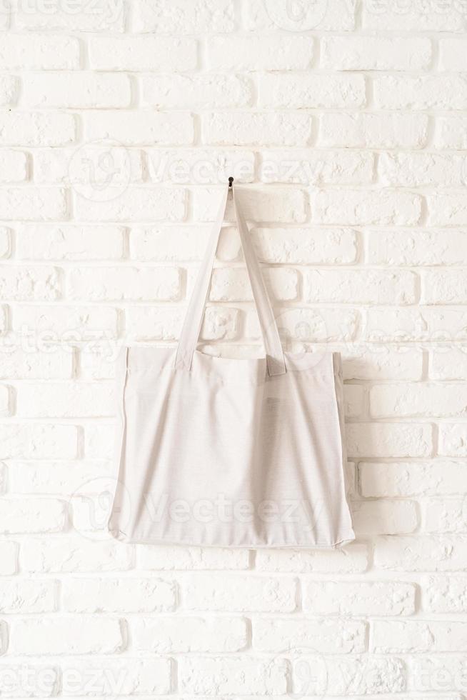 Mock up tote bag eco hipster white cotton fabric on white brick wall photo