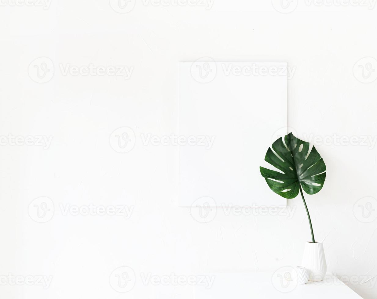 Poster frame on coffee table with decorations on white wall background photo