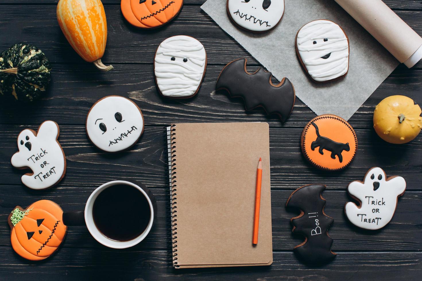 Cup of coffee, gingerbread for Halloween, notebook and pumpkins. photo
