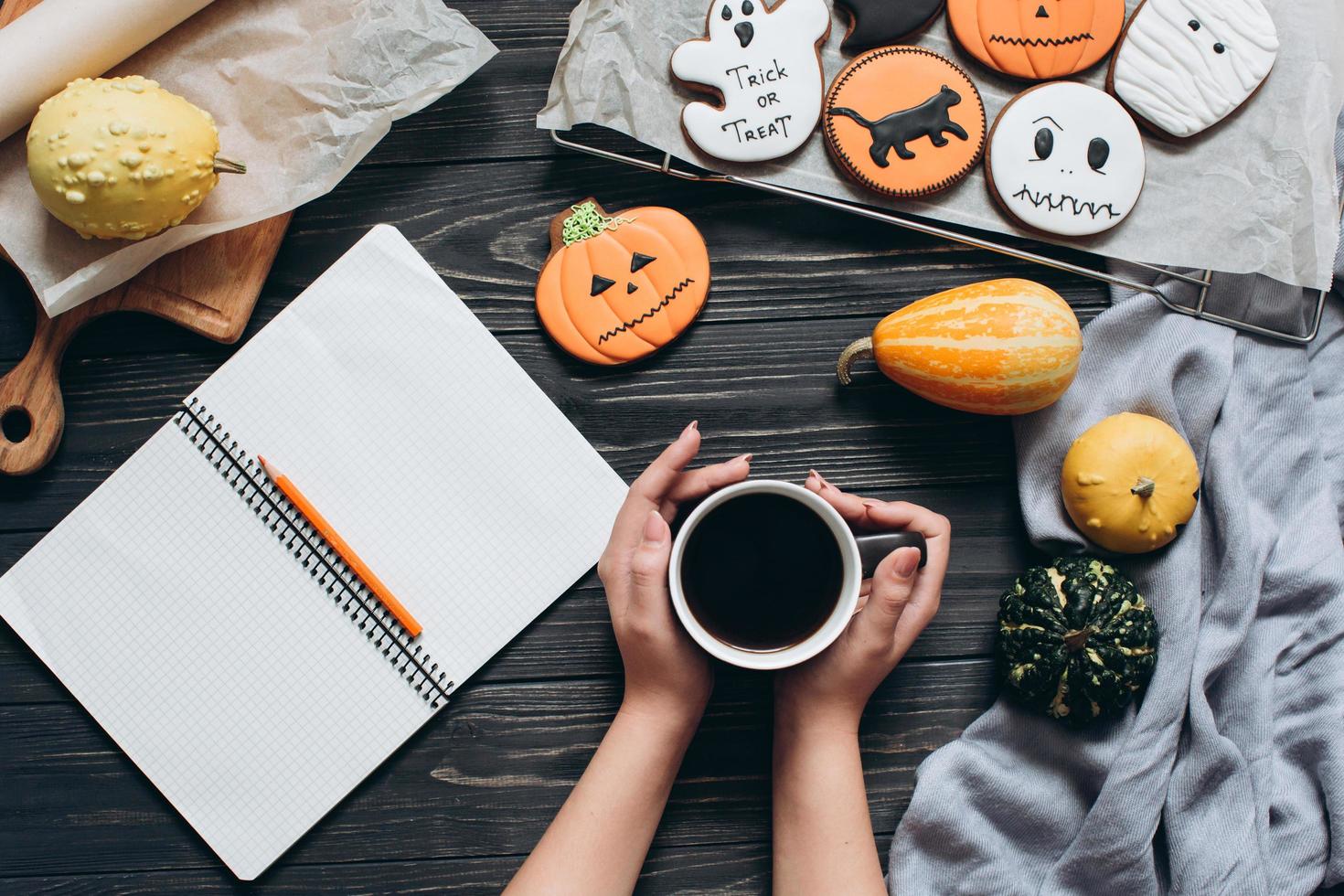 niña sosteniendo una taza de café, pan de jengibre para halloween foto