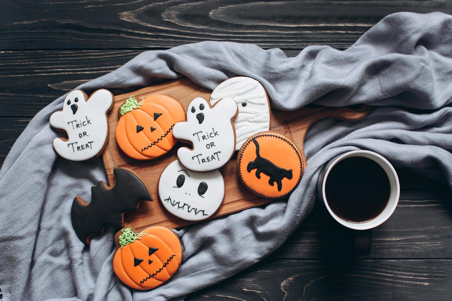 Gingerbreads for halloween with cup of coffee on a black background. photo