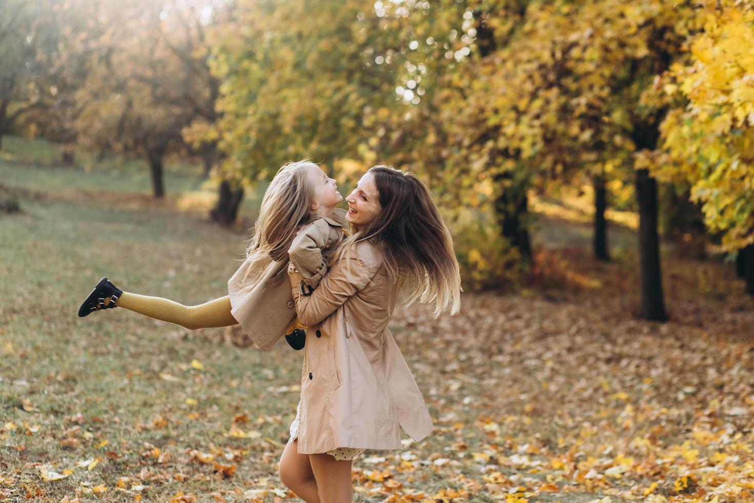 madre y su hija se divierten y caminan en el parque de otoño. foto