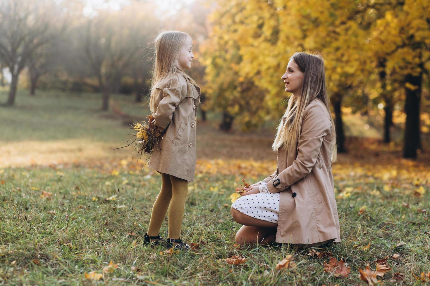 madre y su hija se divierten y caminan en el parque de otoño. foto
