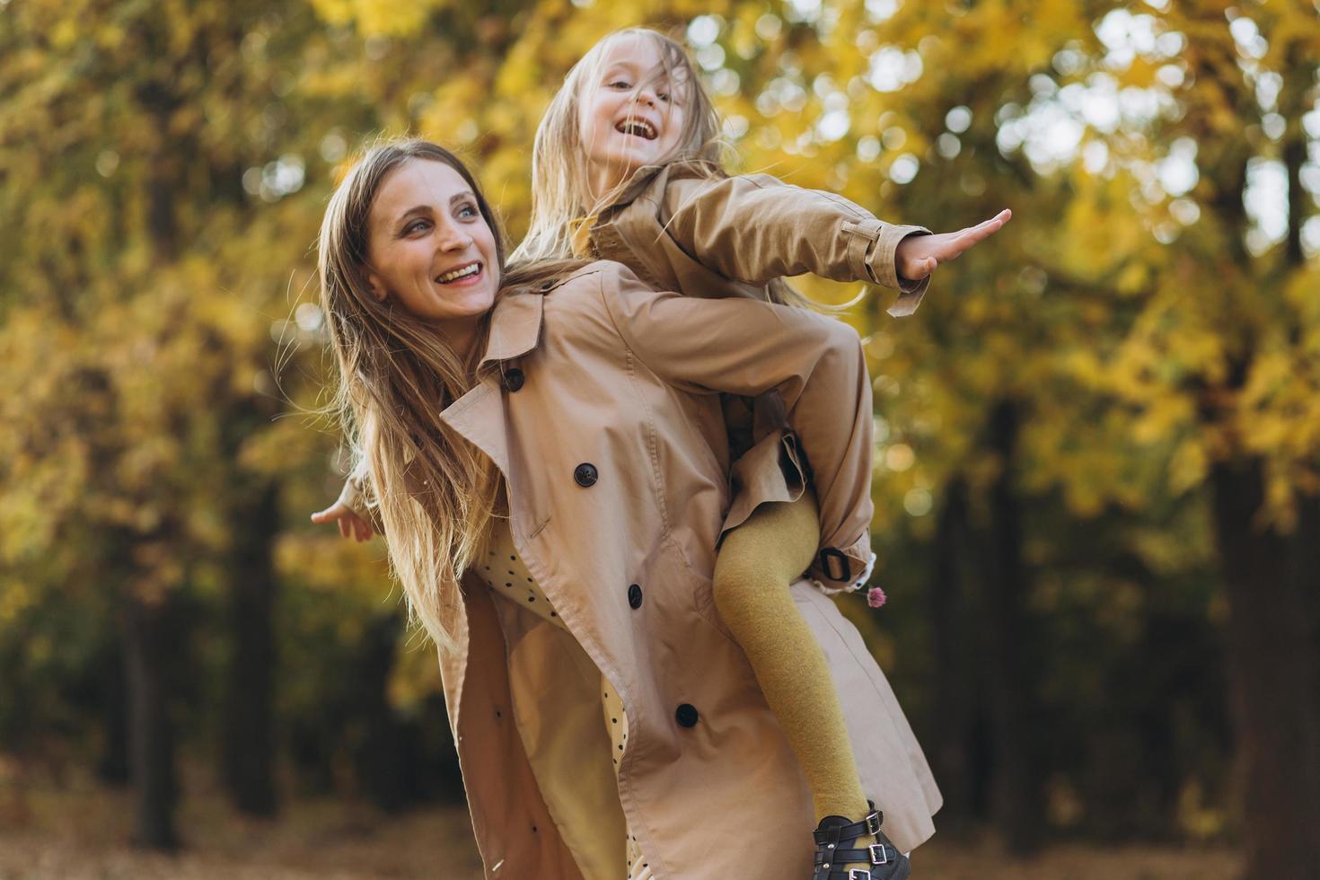 madre y su hija se divierten y caminan en el parque de otoño. foto