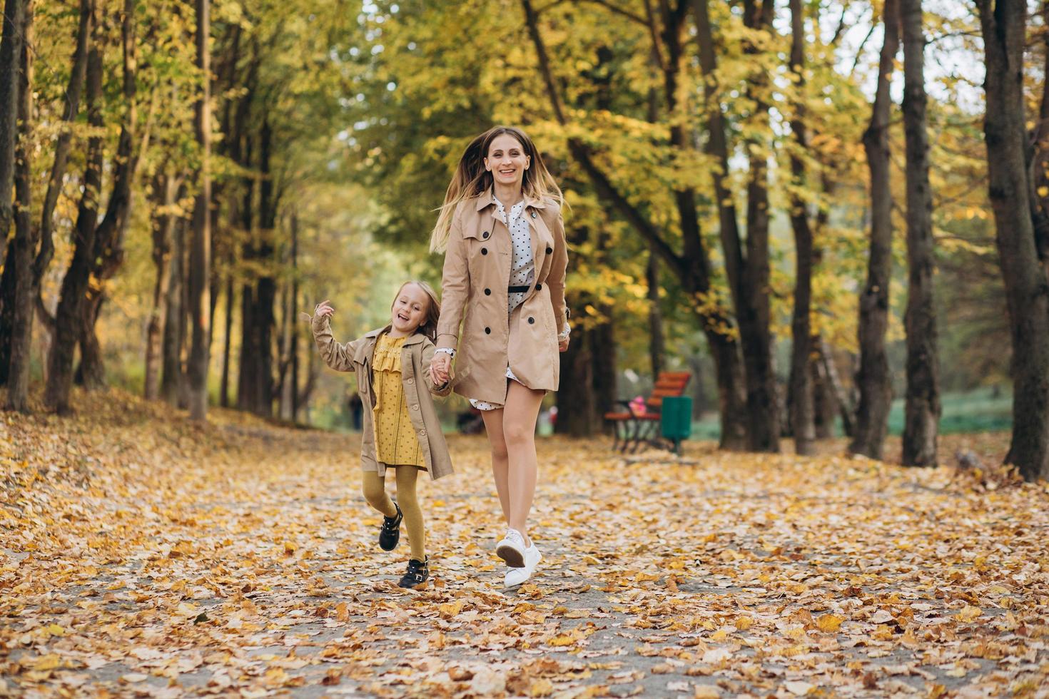 madre y su hija se divierten y caminan en el parque de otoño. foto