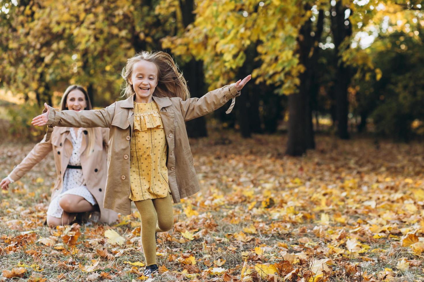 Mother and her daughter have fun and walk in the autumn park. photo