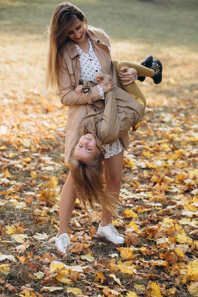 madre y su hija se divierten y caminan en el parque de otoño. foto