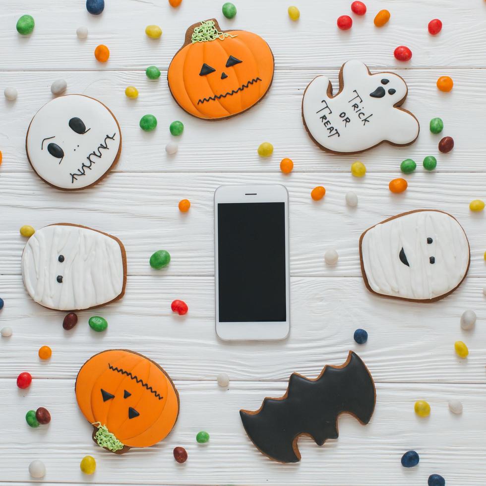 Smartphone with candy and gingerbread photo