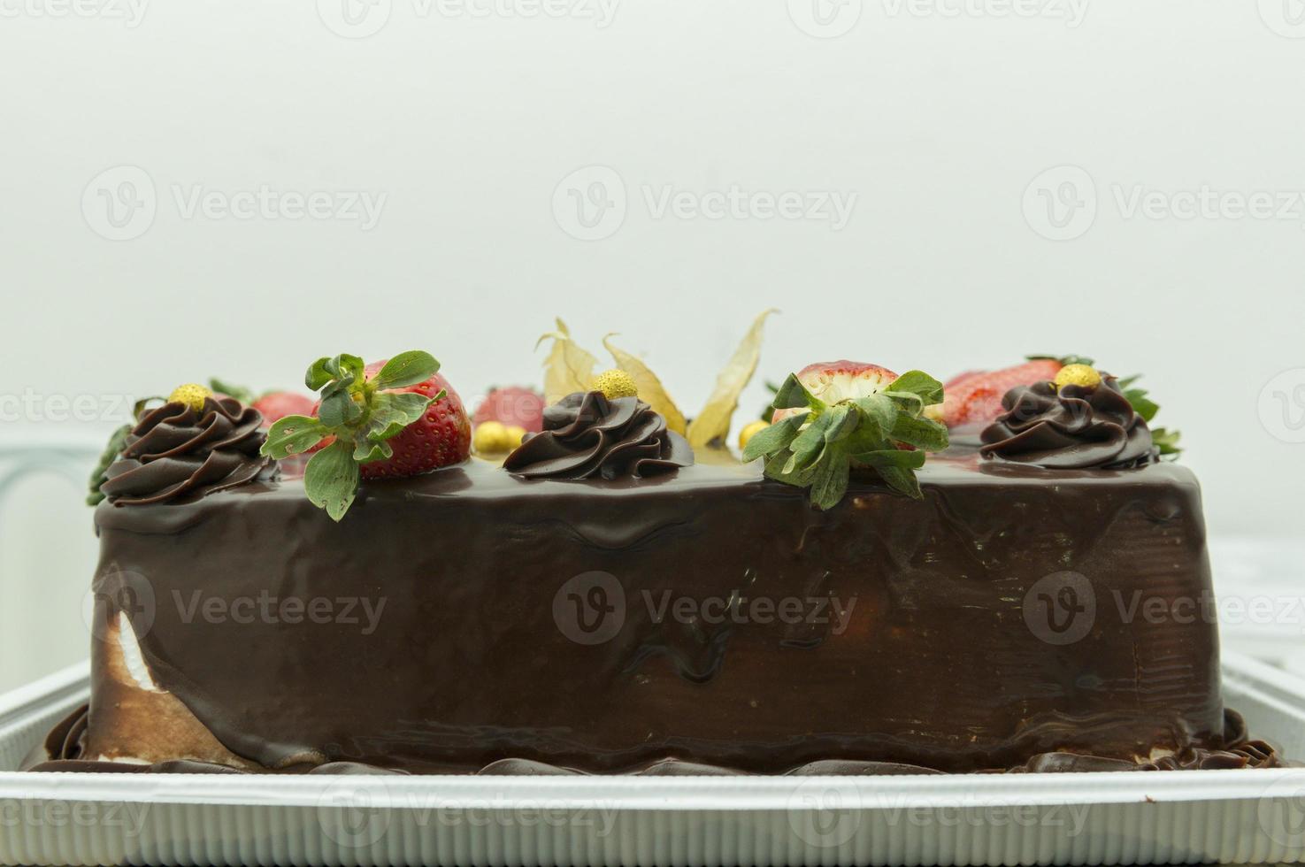 Closeup of chocolate cake with physalis and strawberry. photo