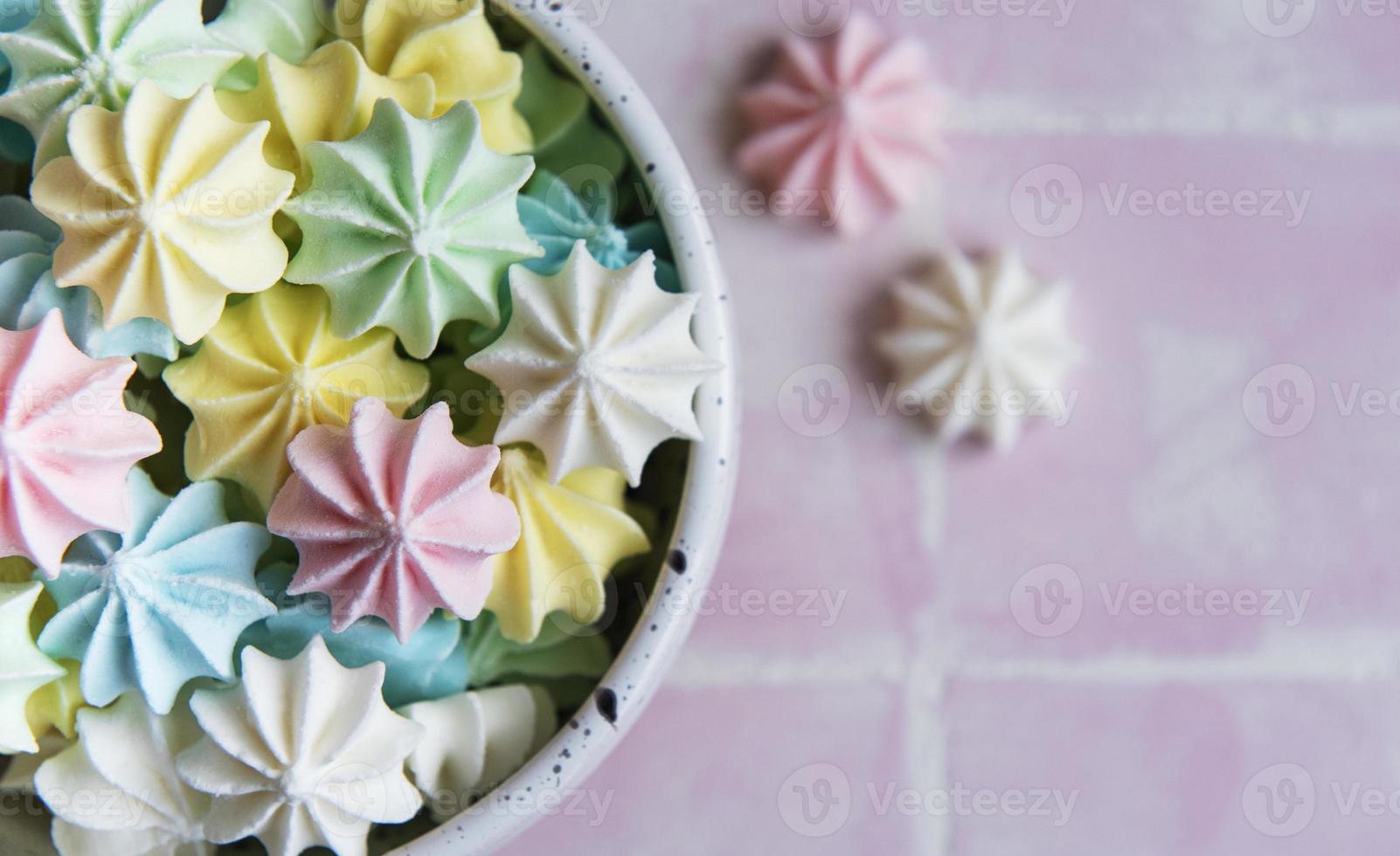 pequeños merengues de colores en el plato de cerámica foto