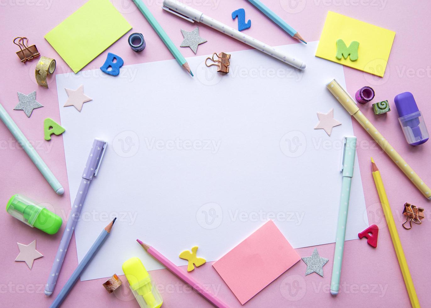 Frame of different stationery on pink background photo