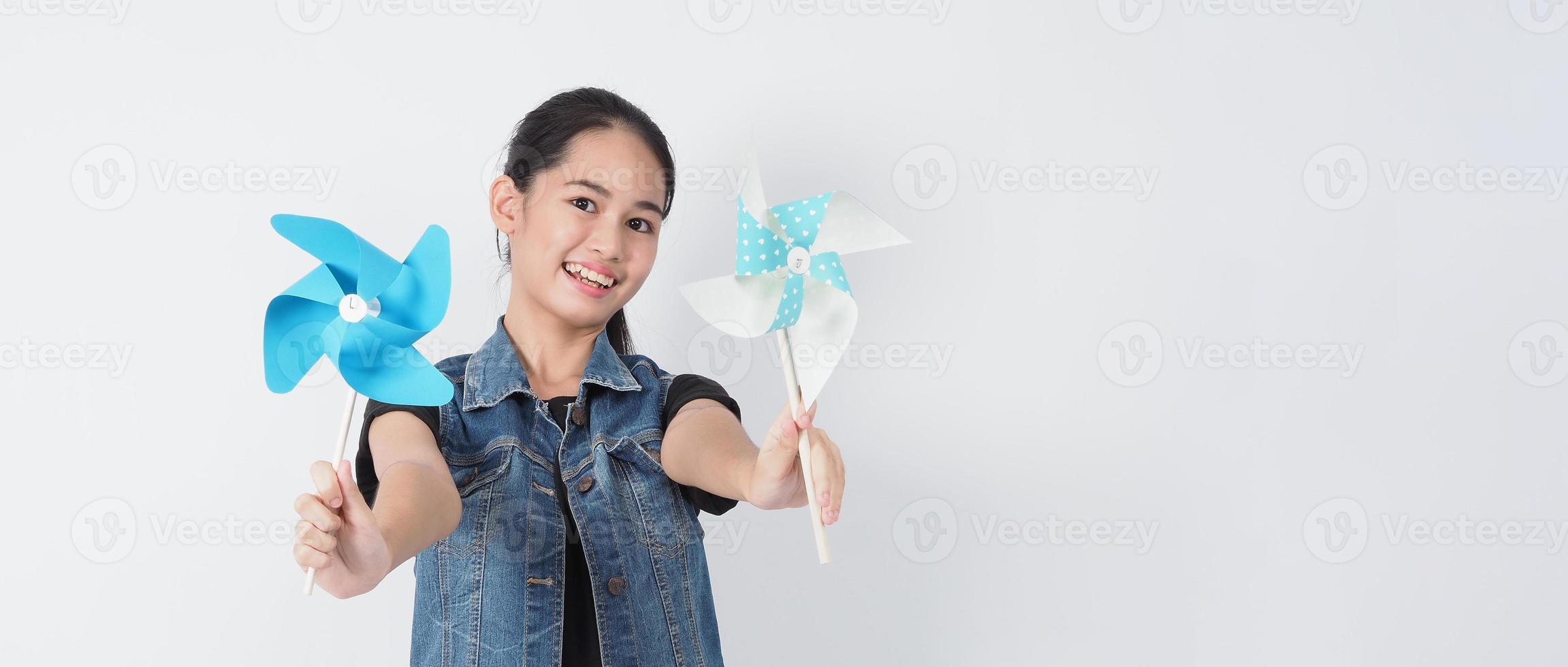 Teenage woman and paper windmill toys. teen with wind wheel stick photo