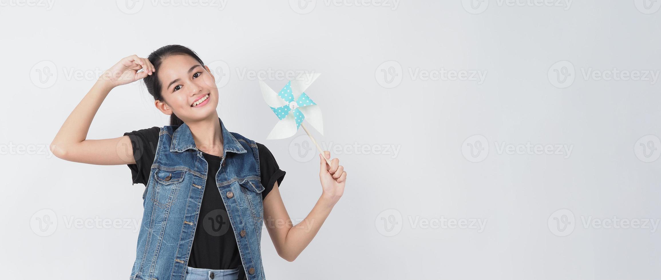 Teenage woman and paper windmill toys. teen with wind wheel stick photo