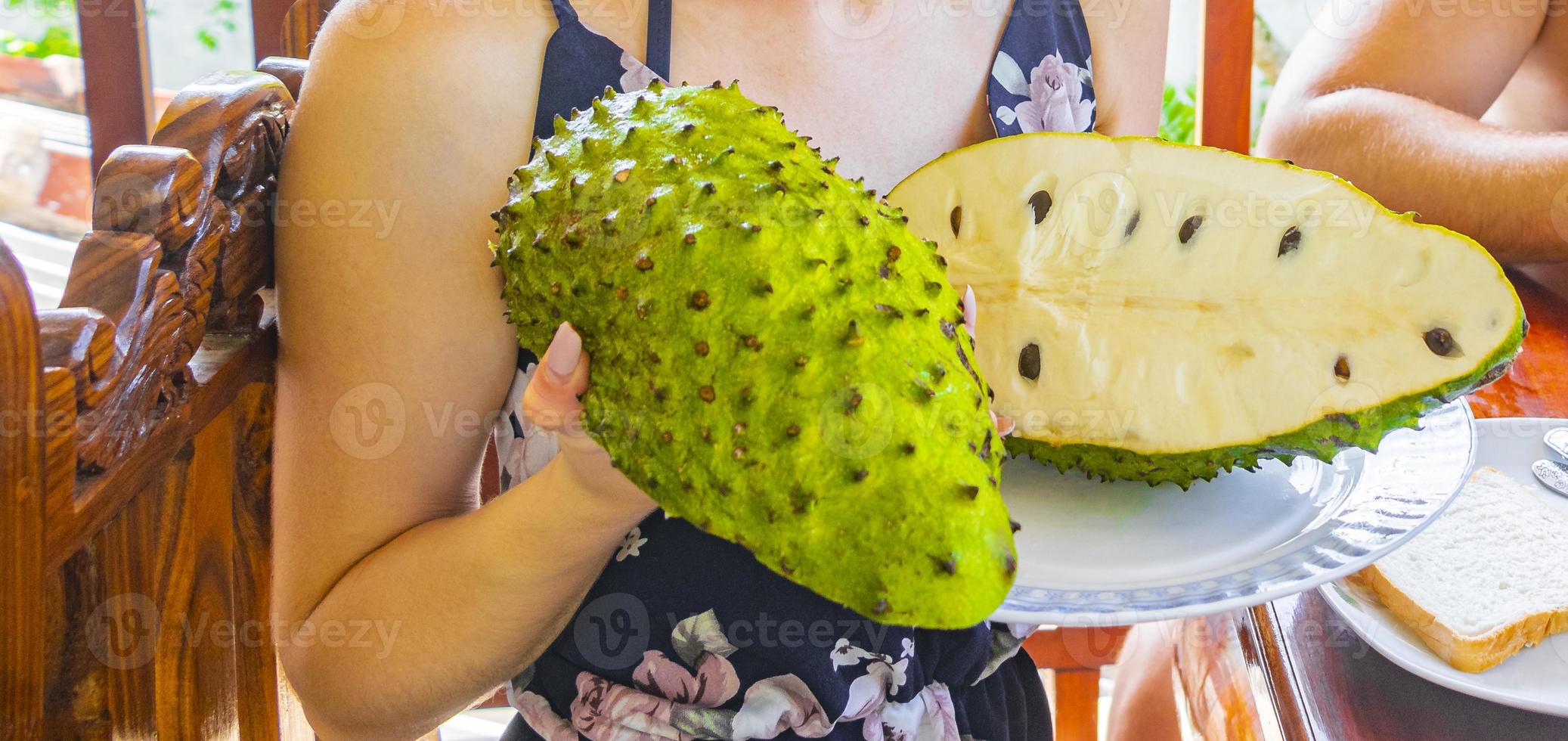 Woman holds sliced soursop Sauersack tropical fruit in Sri Lanka. photo
