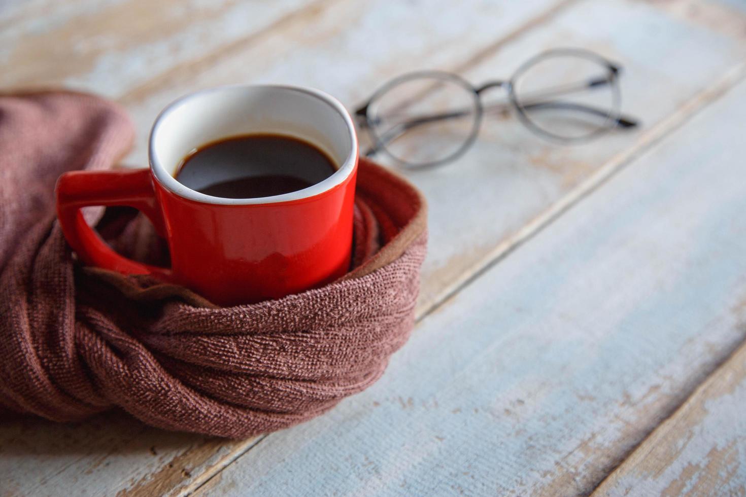 café caliente en taza roja y bufanda en invierno foto