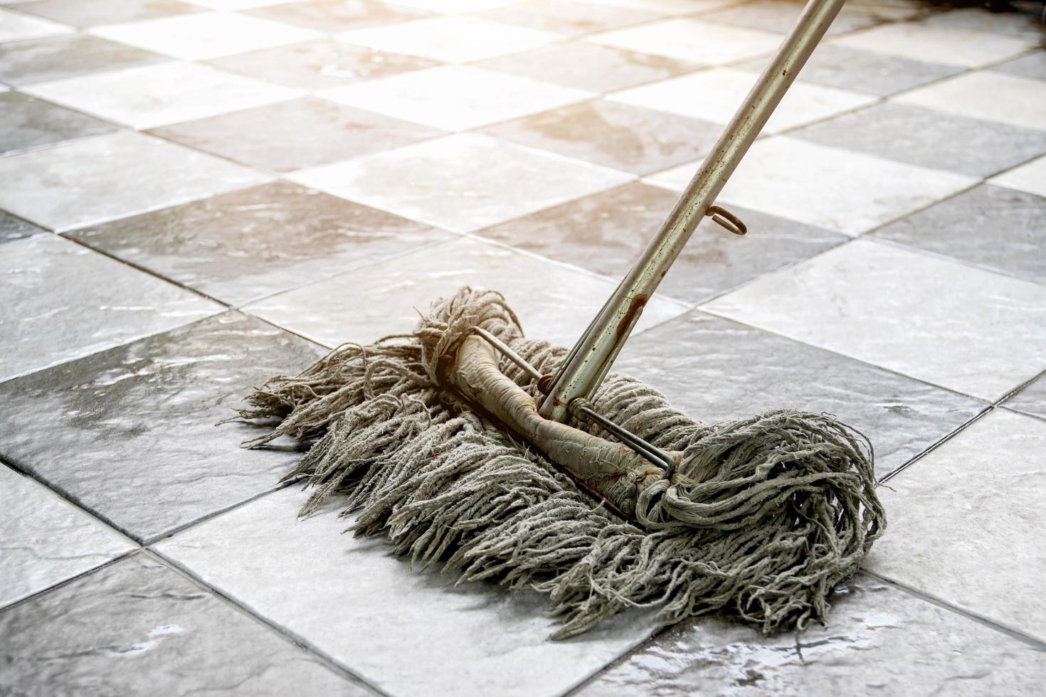 limpie los pisos de baldosas con trapeadores y productos de limpieza para pisos. foto