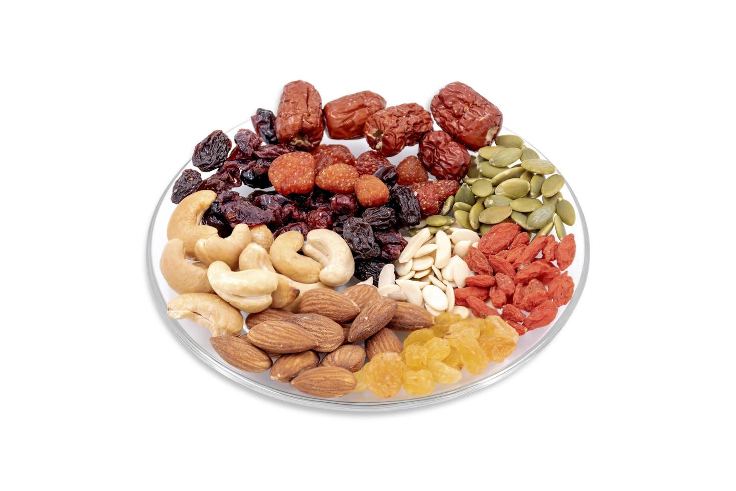 Group of whole grains and dried fruit in a glass plate. photo