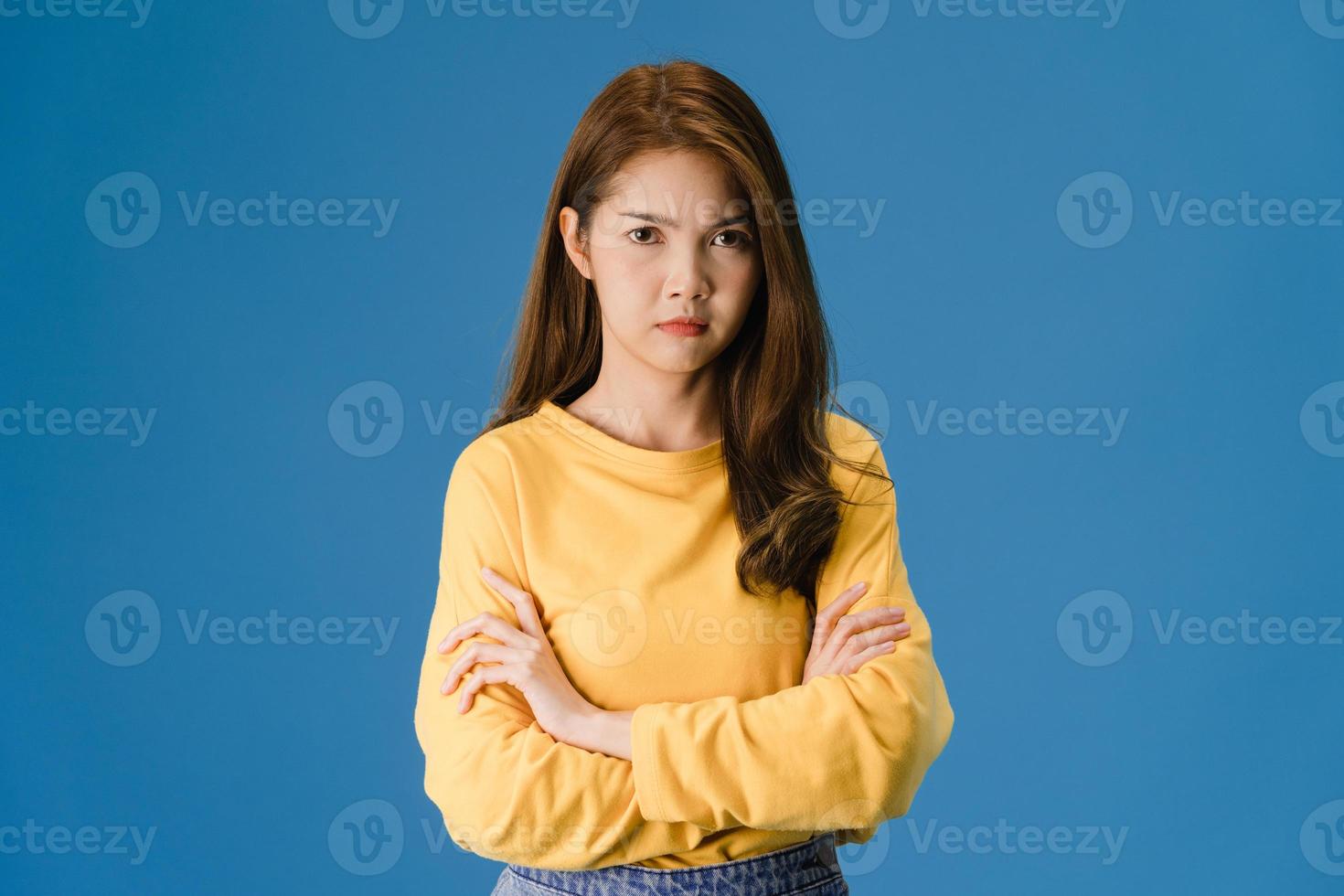 Young Asian lady with negative expression on blue background. photo