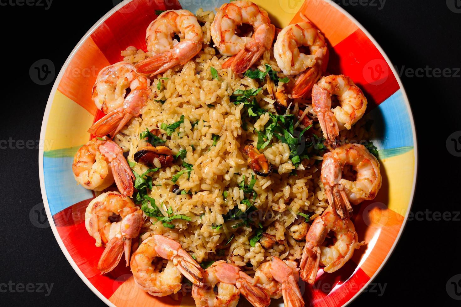 Risotto with mussels and shrimps on a colorful beautiful plate photo