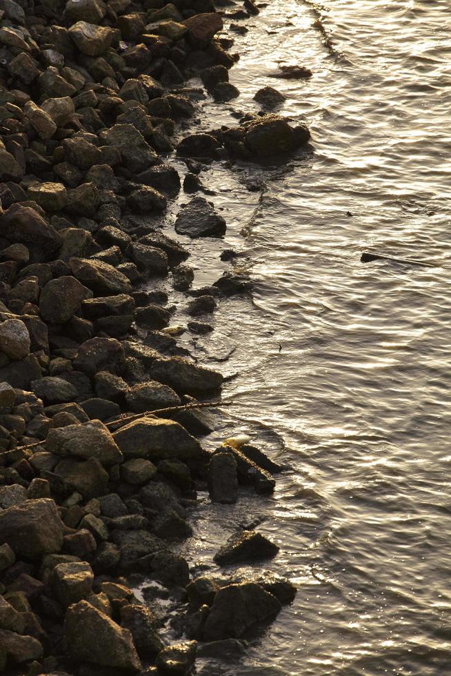 Stone and sea wave in sunset photo