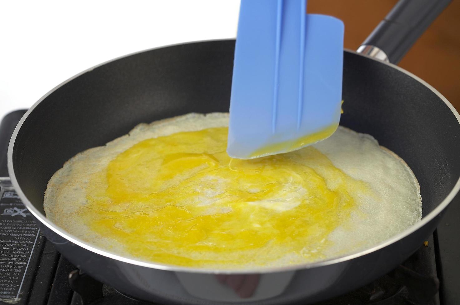 Cooking pancake with egg in kitchen photo