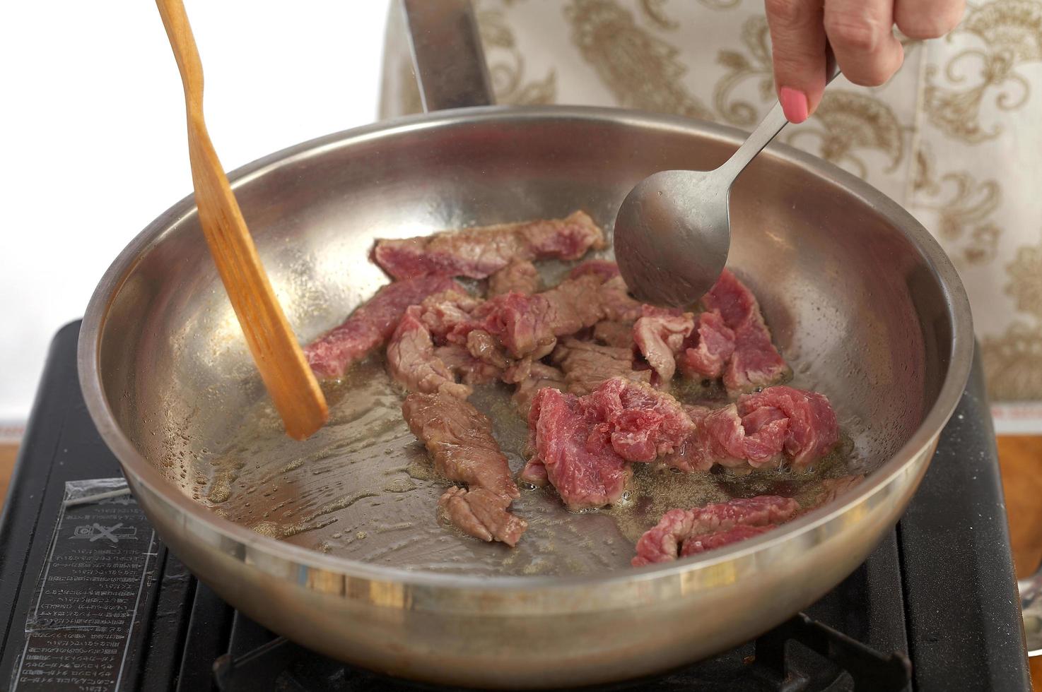 Cooking beef fry in metal pan photo