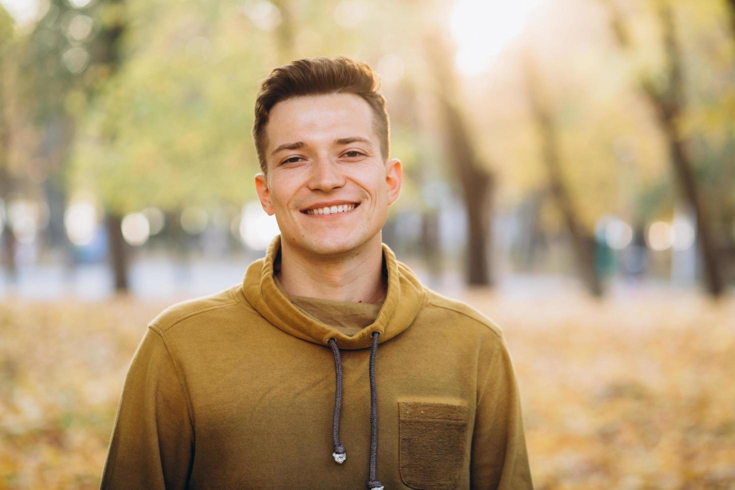 retrato, de, guapo, chico, sonriente, en, el, otoño, parque foto