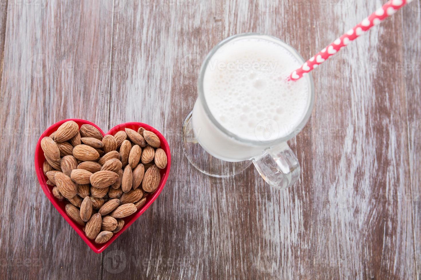 Almendras en un recipiente en forma de corazón con leche desde arriba foto