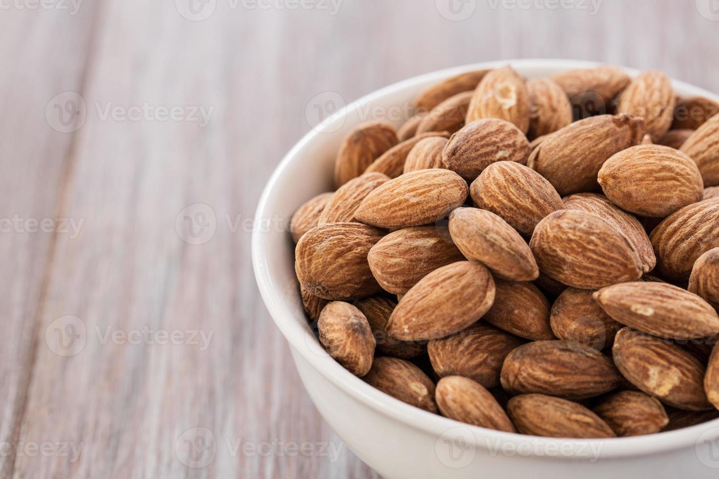 Cerrar tazón lleno de almendras foto