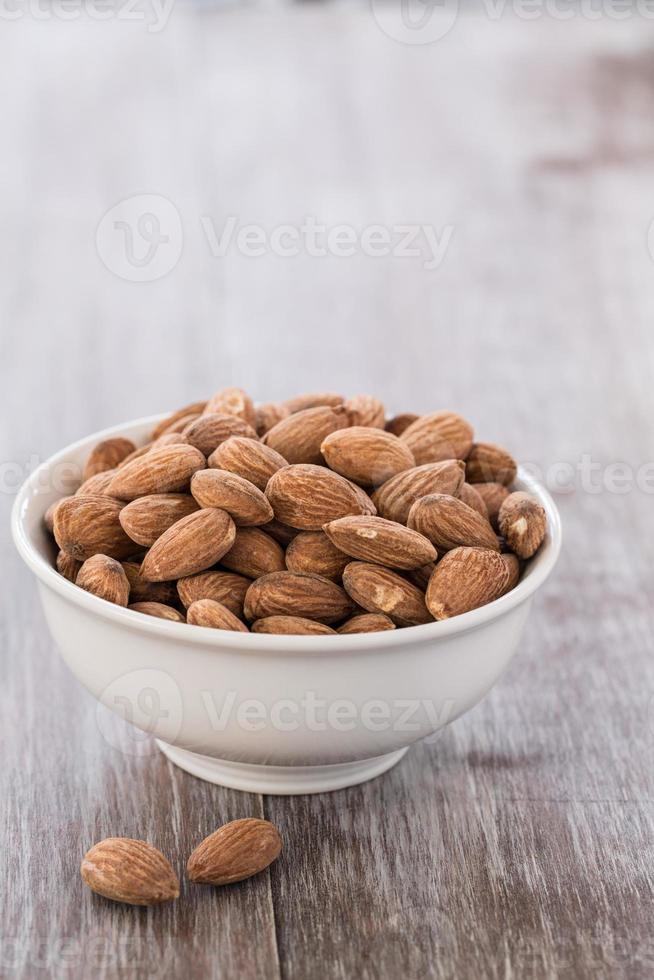 White Bowl of Almonds on Wood Background photo