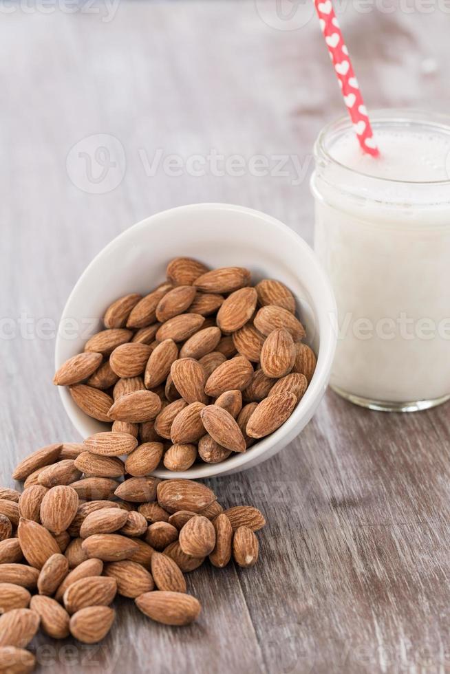 Almonds Spilling From White Bowl With Almond Milk photo