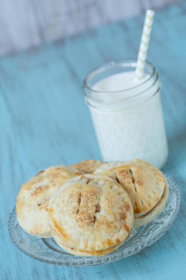 pequeñas tartas de manzana con un vaso de leche foto