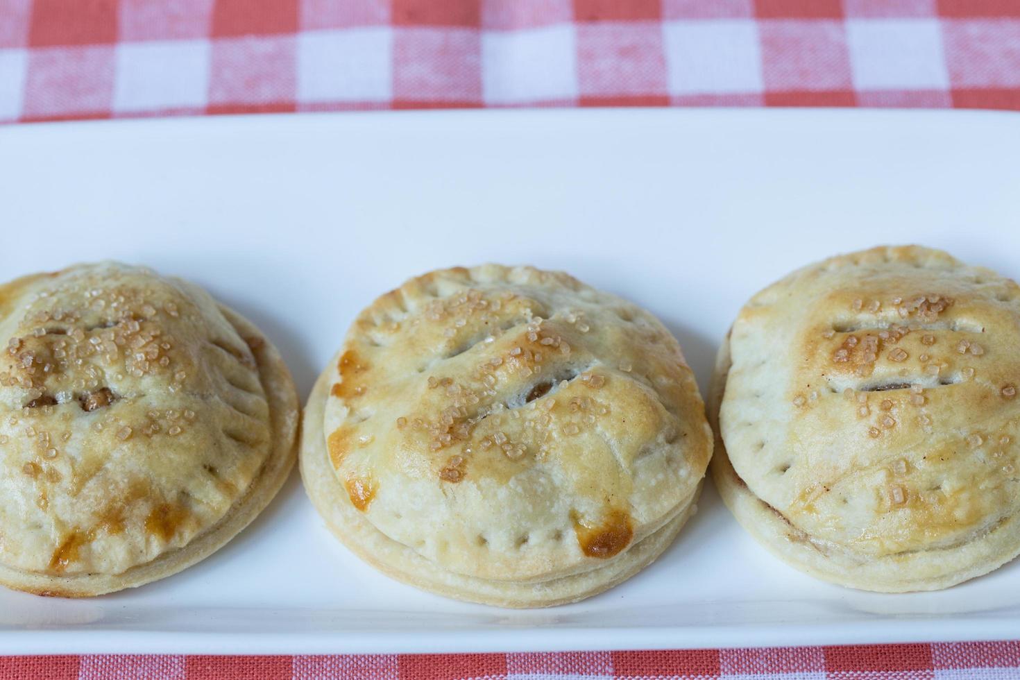 Apple Hand Pies In a Row On Red Napkin photo