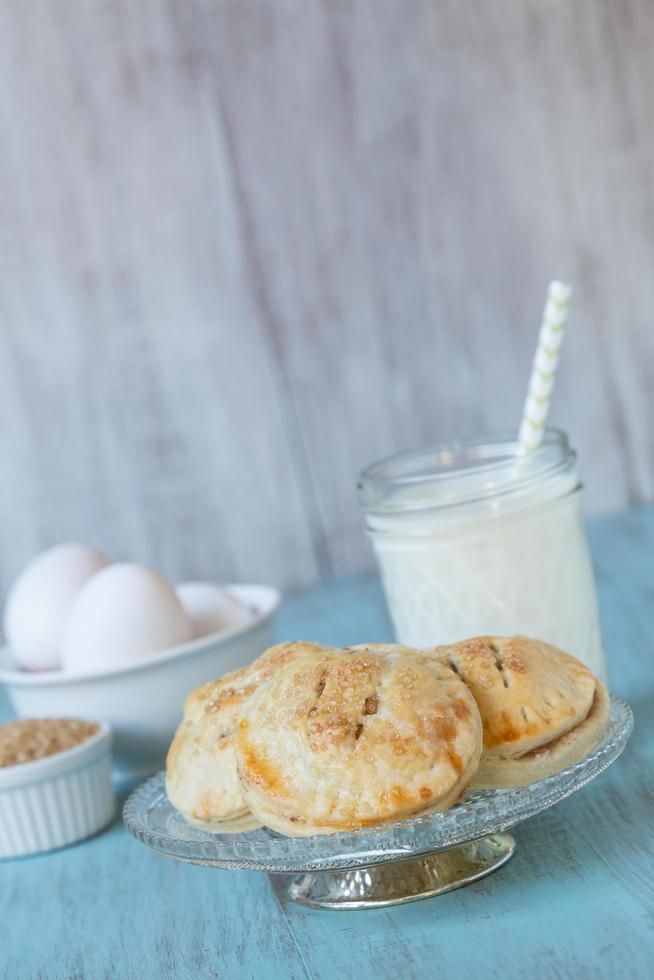 Apple Hand Pies With Milk and Eggs On Antique Plate photo