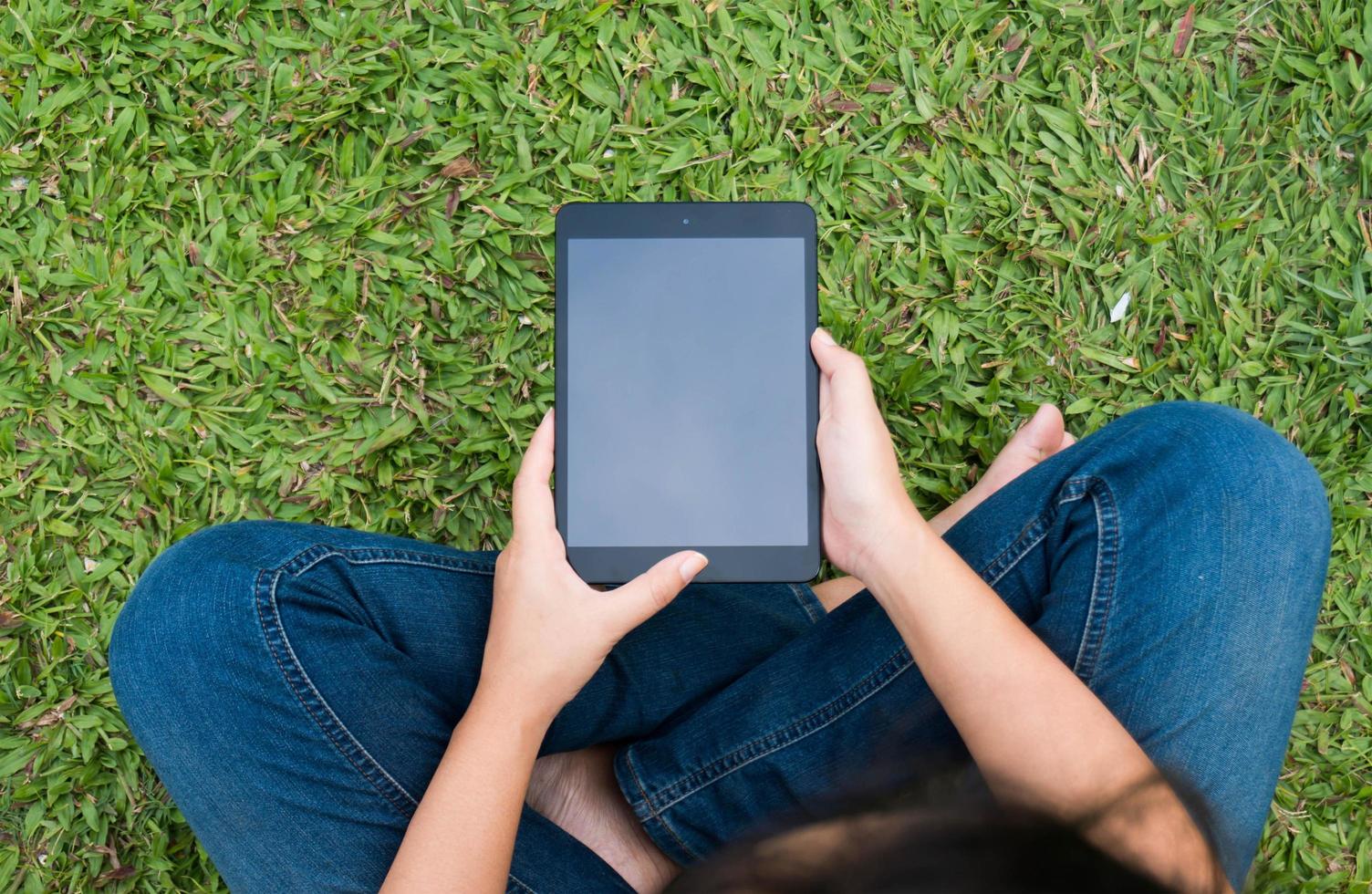 Top view girl sitting on the floor and working with tablet photo