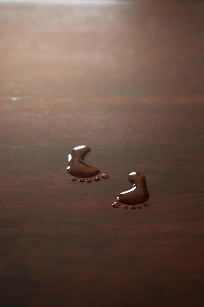 Spoor footmark by art water drops on wood table background. photo