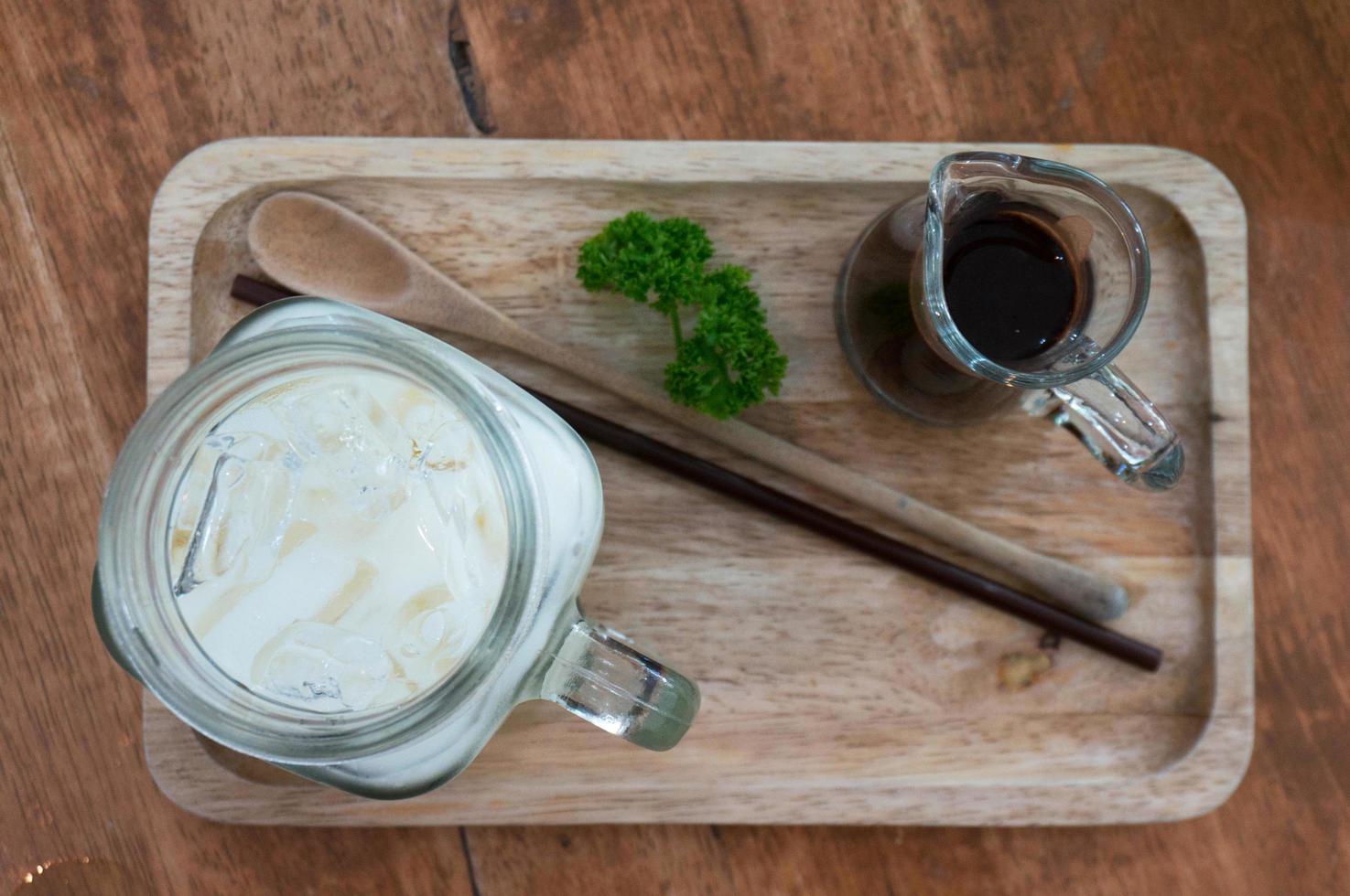 café helado separado con leche en la vista superior de la mesa de madera. foto