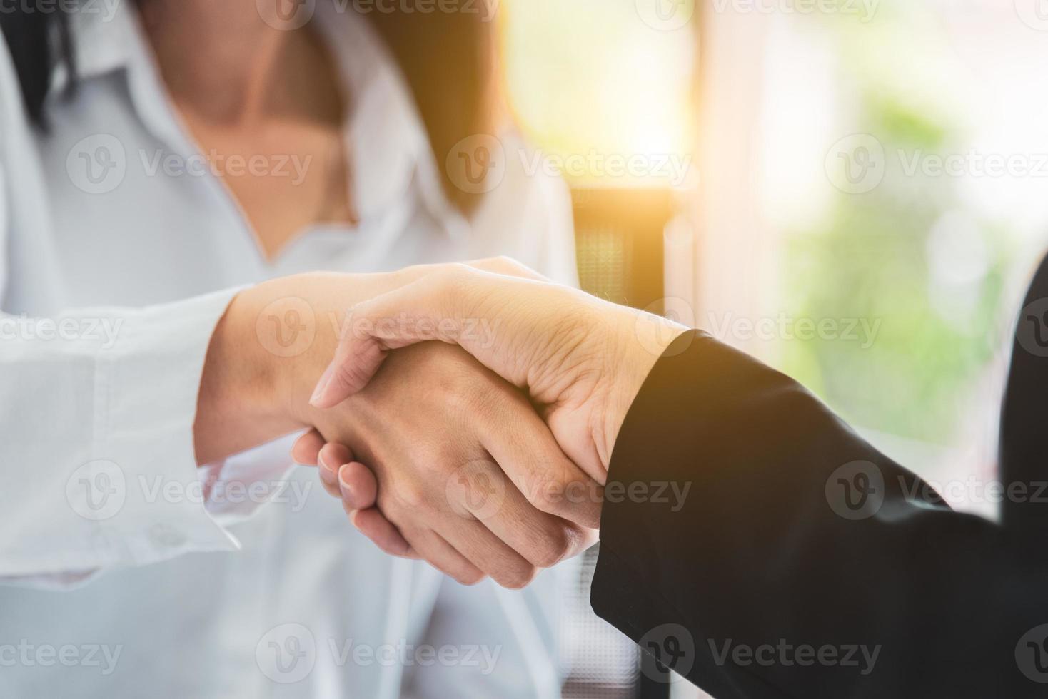 Close up of business people shaking hands after finish agreement photo