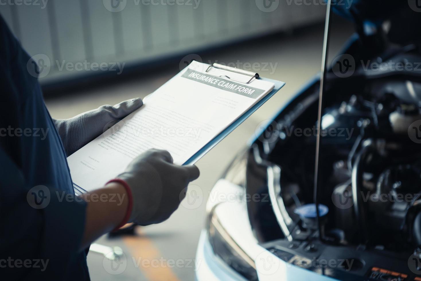 mecánico de automóviles sosteniendo el portapapeles y comprobando el mantenimiento foto