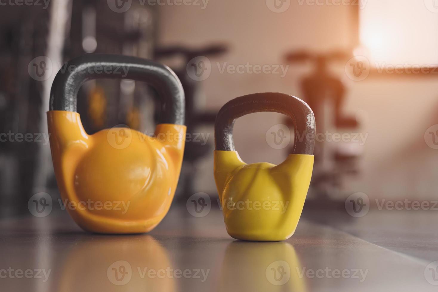 Kettlebells or dumbbells on fitness gym floor photo