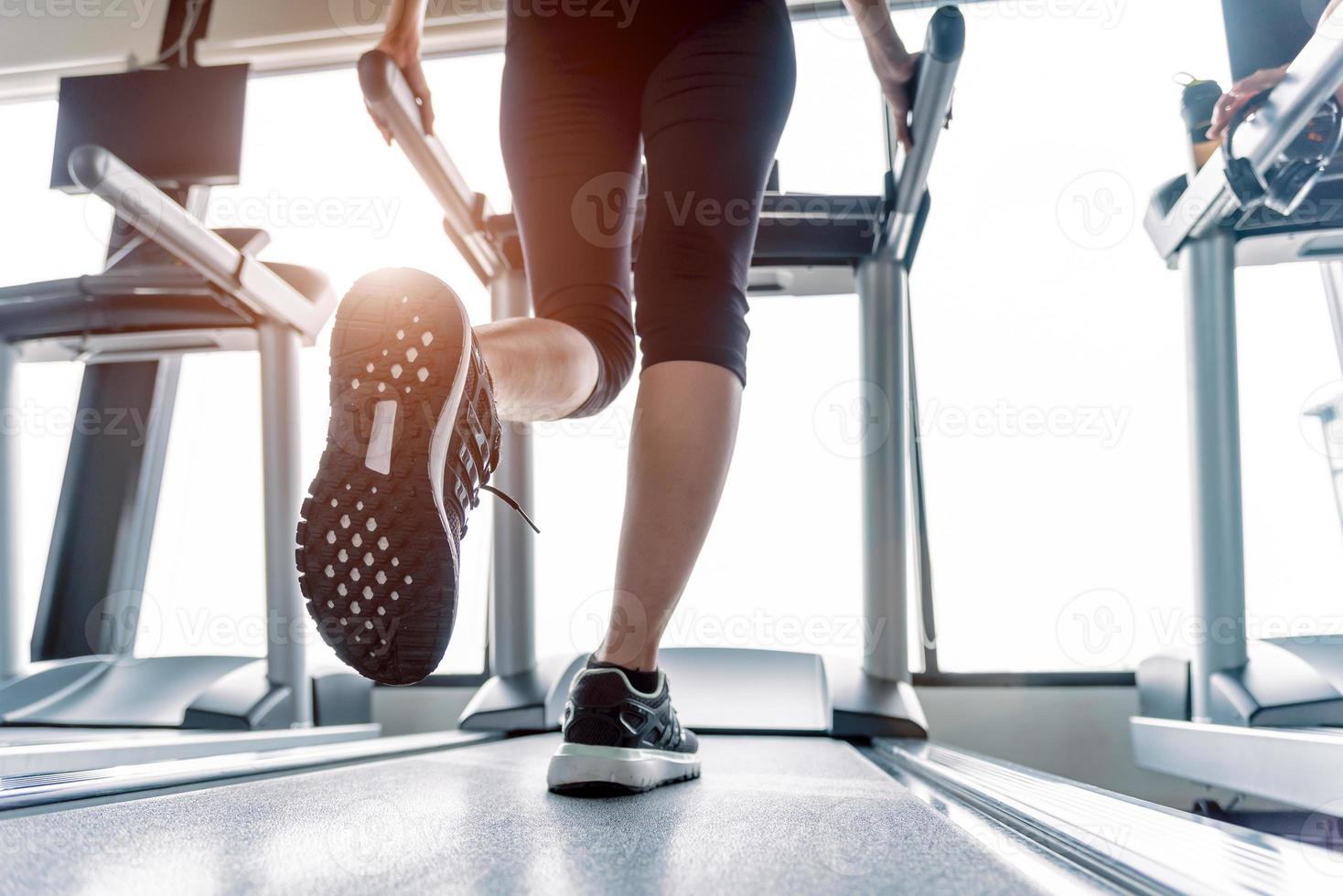 Lower body at legs part of Fitness girl on treadmill photo