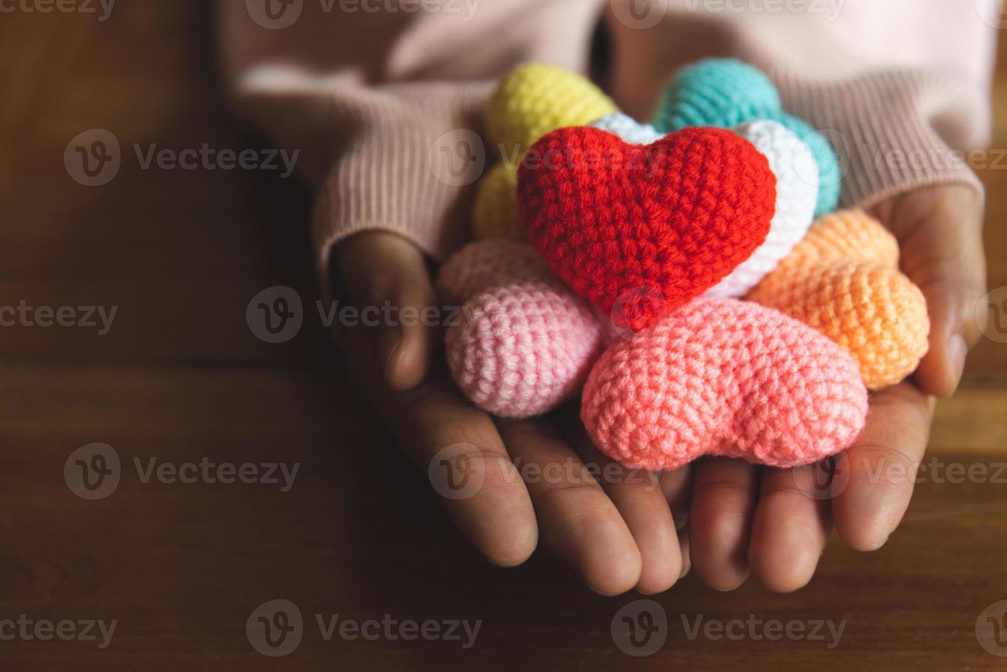 Mixed colors yarn heart on giving hands photo