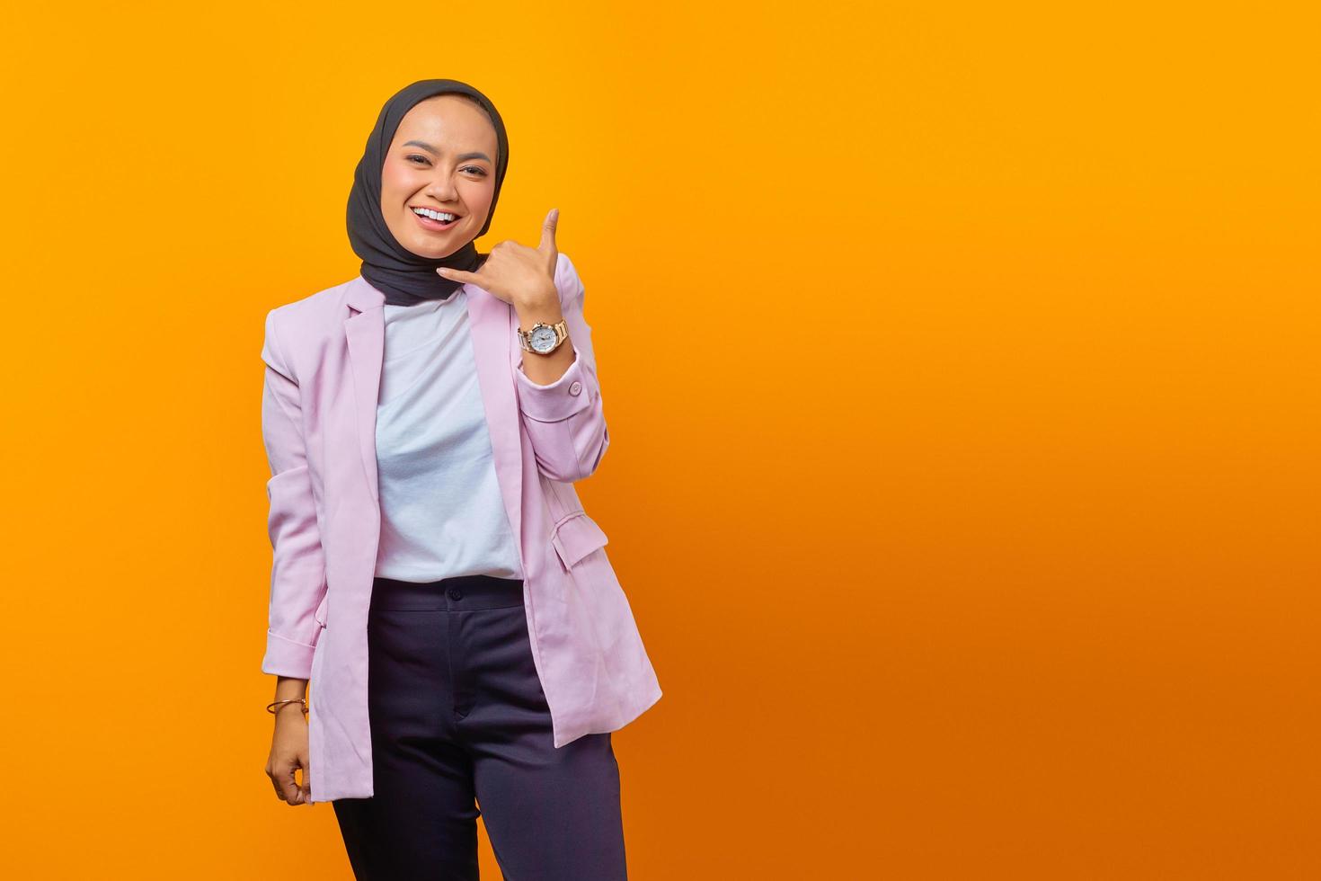 Beautiful Asian woman smiling doing call gesture with hand photo