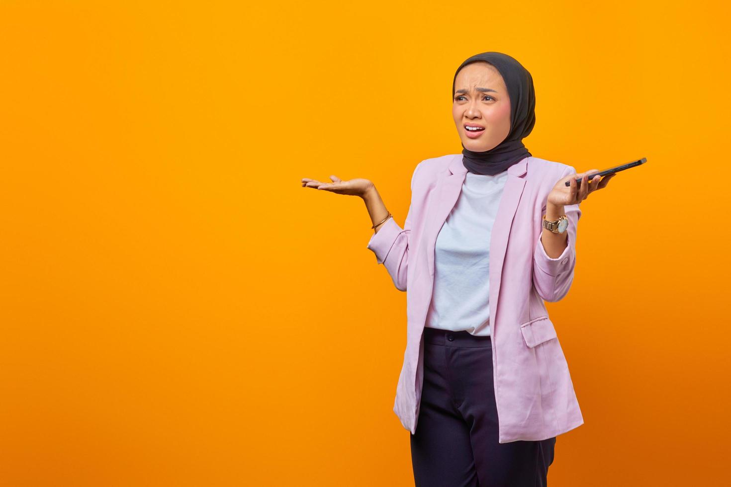 Portrait of young angry Asian woman raising palms confusedly photo