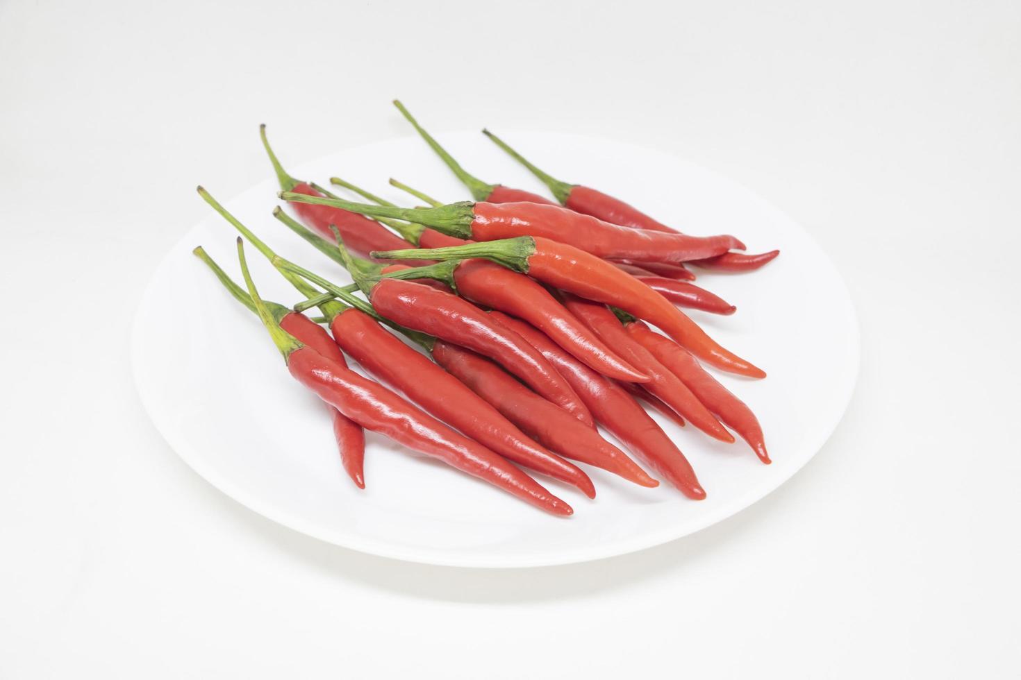 Red peppers on a white plate On a white background photo