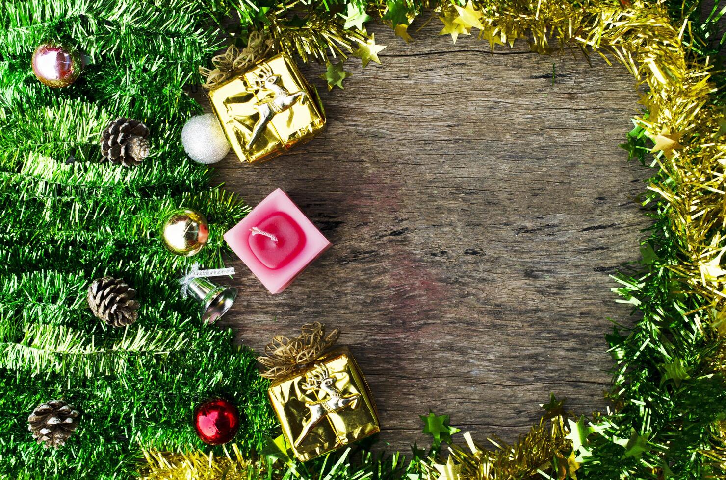 Caja de regalo de oro de navidad y velas sobre fondos de madera arriba foto