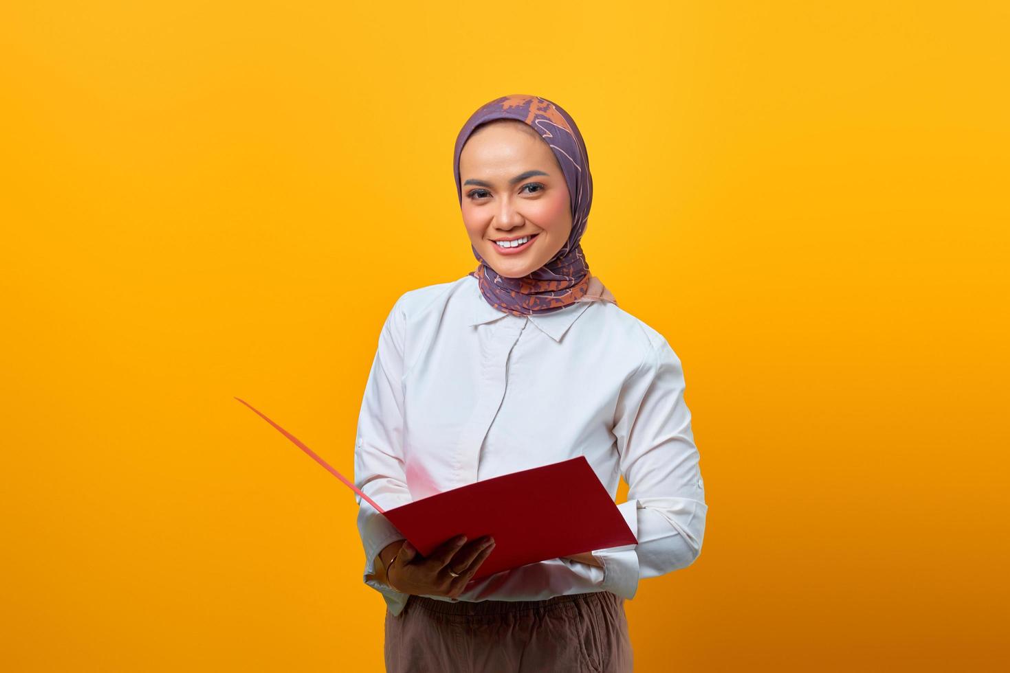 Beautiful Asian woman holding folders while looking at camera photo