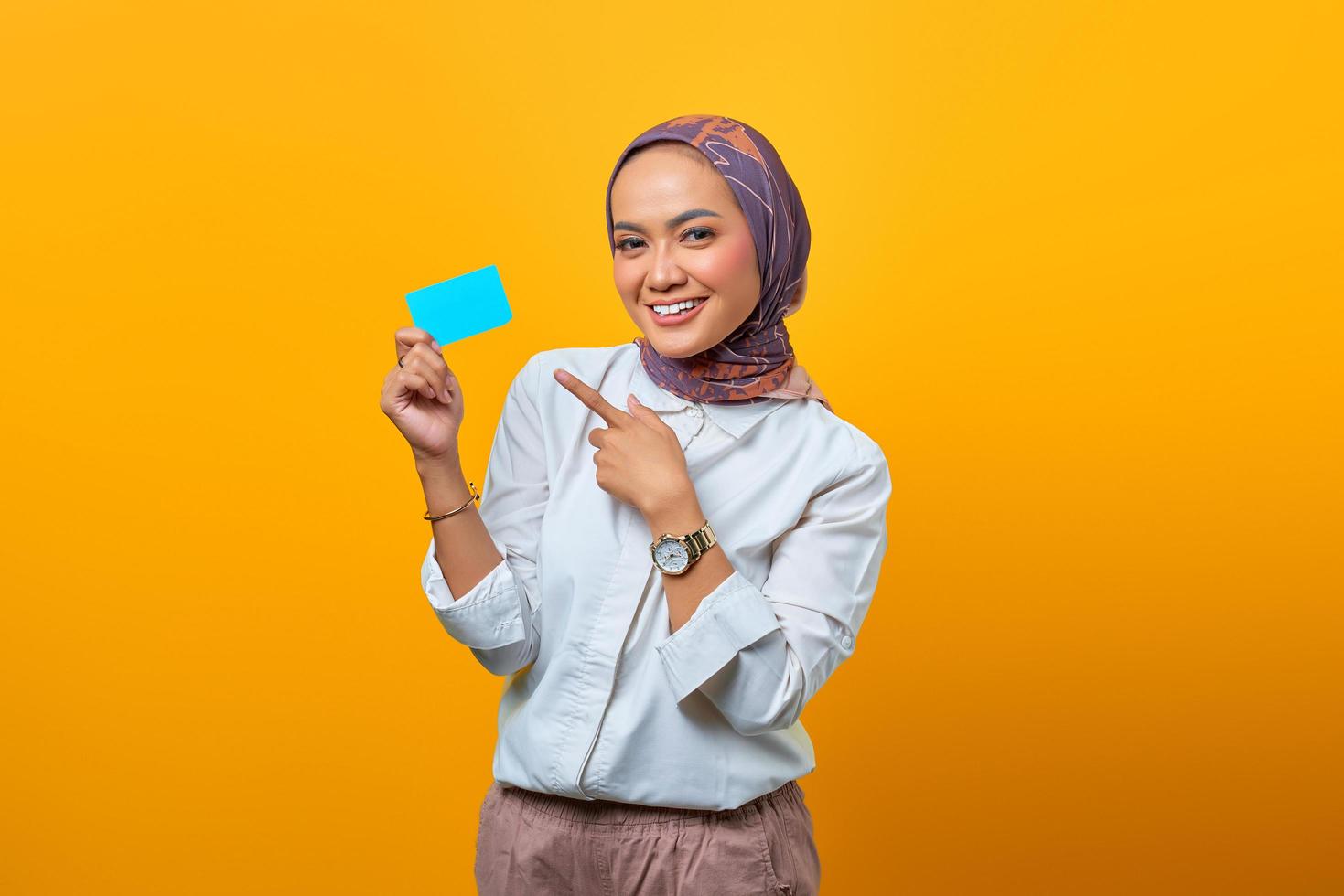 Beautiful Asian woman pointing blank card and looking at camera photo