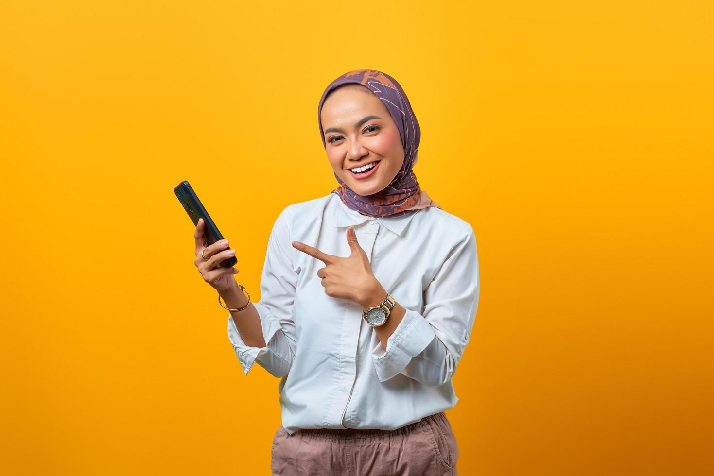 retrato, de, sonriente, mujer asiática, señalar, smartphone foto